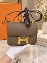 Hermès Constance 24 Brown Epsom Leather Crossbody Shoulder Bag shown in a lifestyle setting.