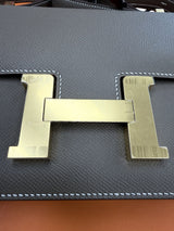 Close-up of the gold H clasp on the Hermès Constance 24 Brown Epsom Leather Crossbody Shoulder Bag.